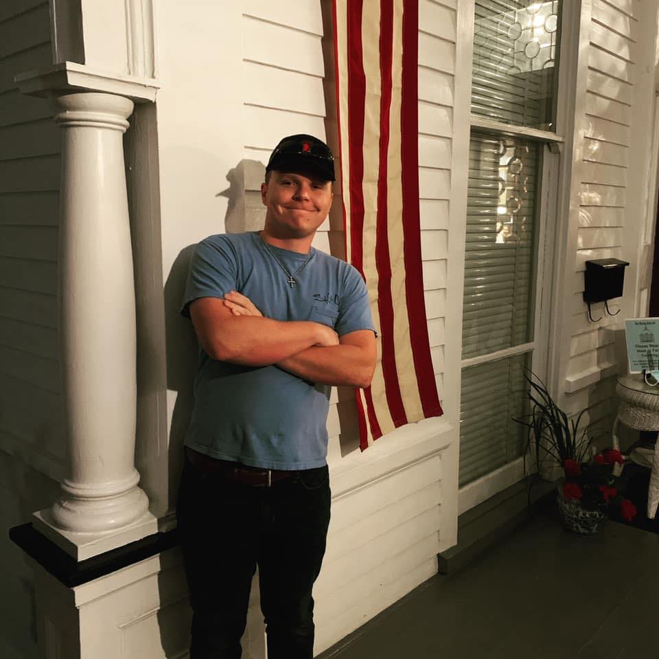 Brison Culpepper standing next to American flag
